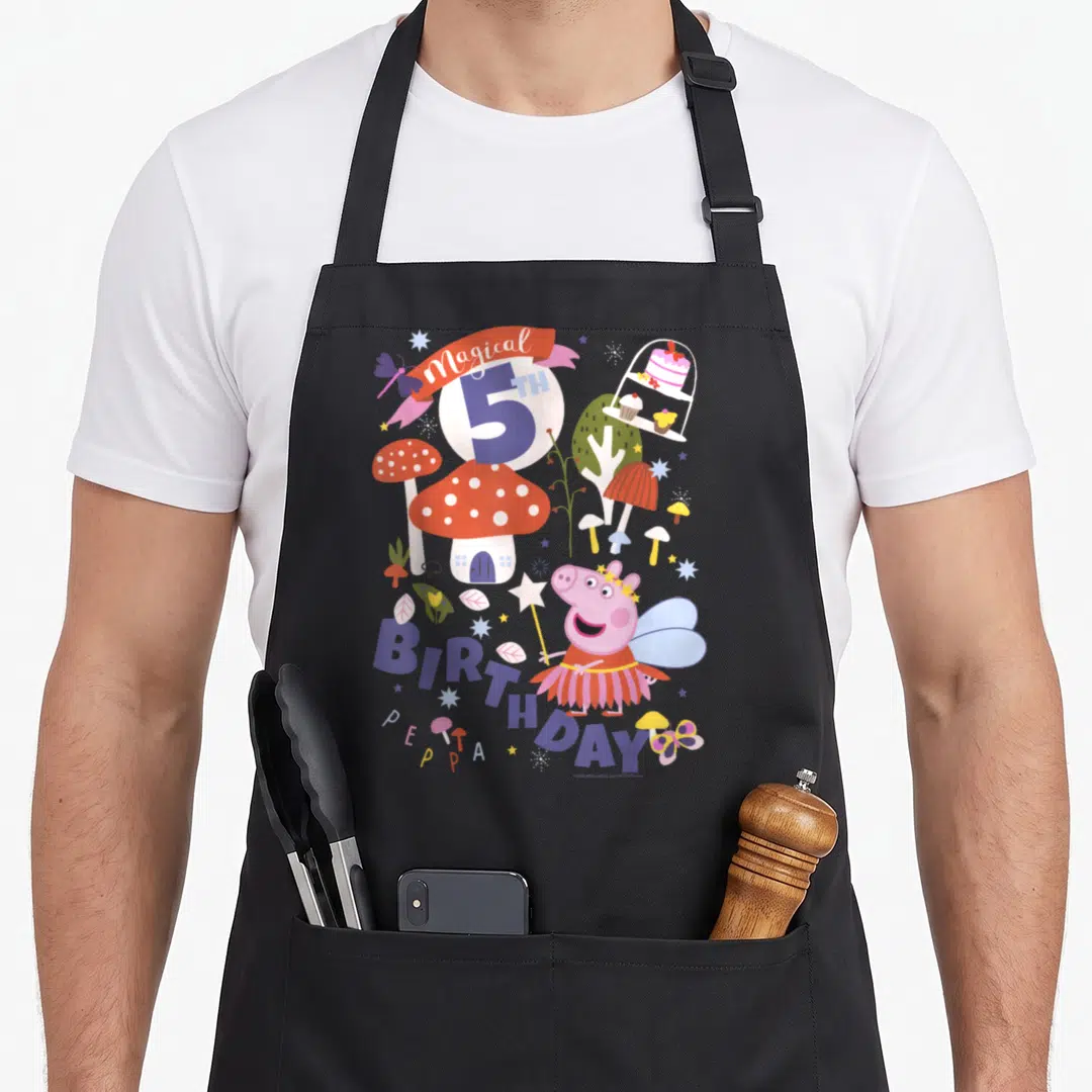 Magical 5th birthday apron - Peppa Pig fairy holding wand near red mushroom house and cake stand with 5TH BIRTHDAY text — shown on a black cotton canvas apron against a white background