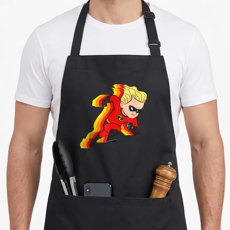 Incredible running apron - Superhero boy in red suit with yellow and orange motion trails trailing behind in cartoon — shown on a black cotton canvas apron against a white background