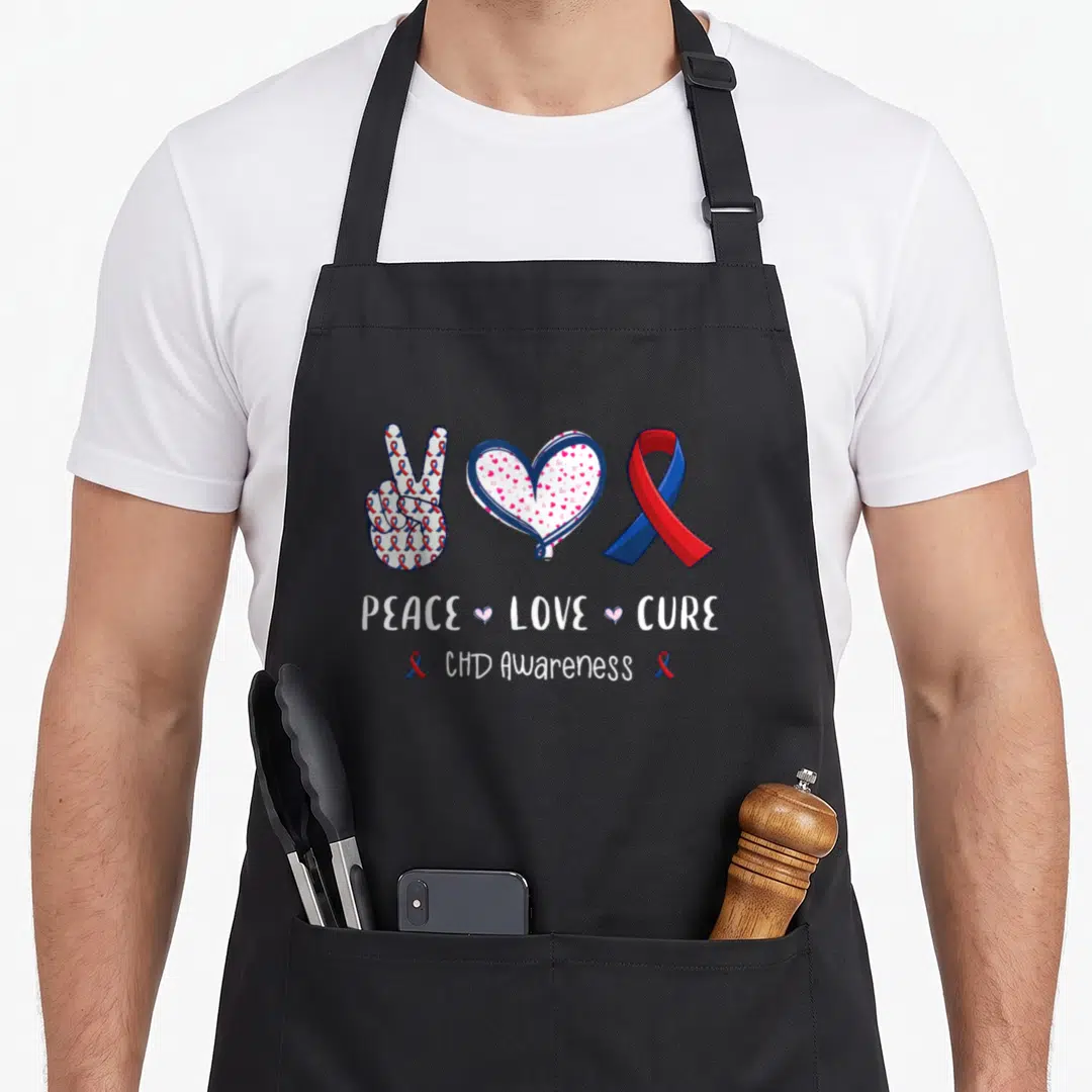 Cure heart disease awareness apron - Peace sign and heart filled with ribbons above PEACE LOVE CURE CHD Awareness text — shown on a black cotton canvas apron against a white background