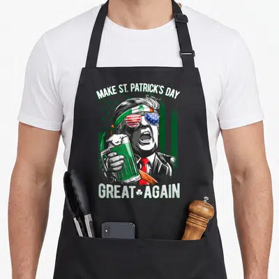 Trump irish aprons - Cartoon man with shamrock headband holding green beer under Make St Patrick's Day Great Again text — shown on a black cotton canvas apron against a white background