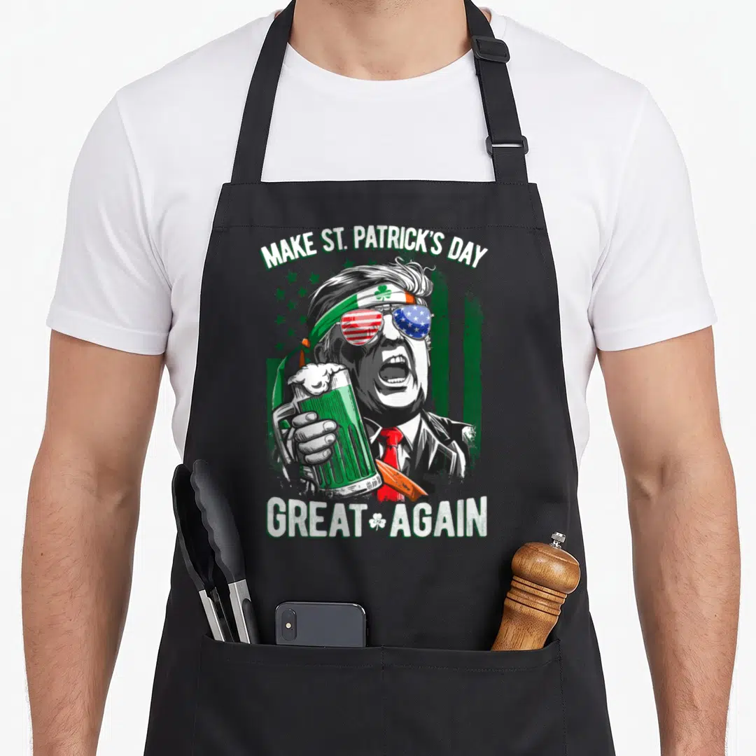 Trump irish aprons - Cartoon man with shamrock headband holding green beer under Make St Patrick's Day Great Again text — shown on a black cotton canvas apron against a white background