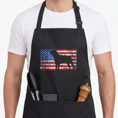 Flag rottweiler 4th of july apron - Grey dog silhouette standing in front of a distressed red white and blue flag — shown on a black cotton canvas apron against a white background