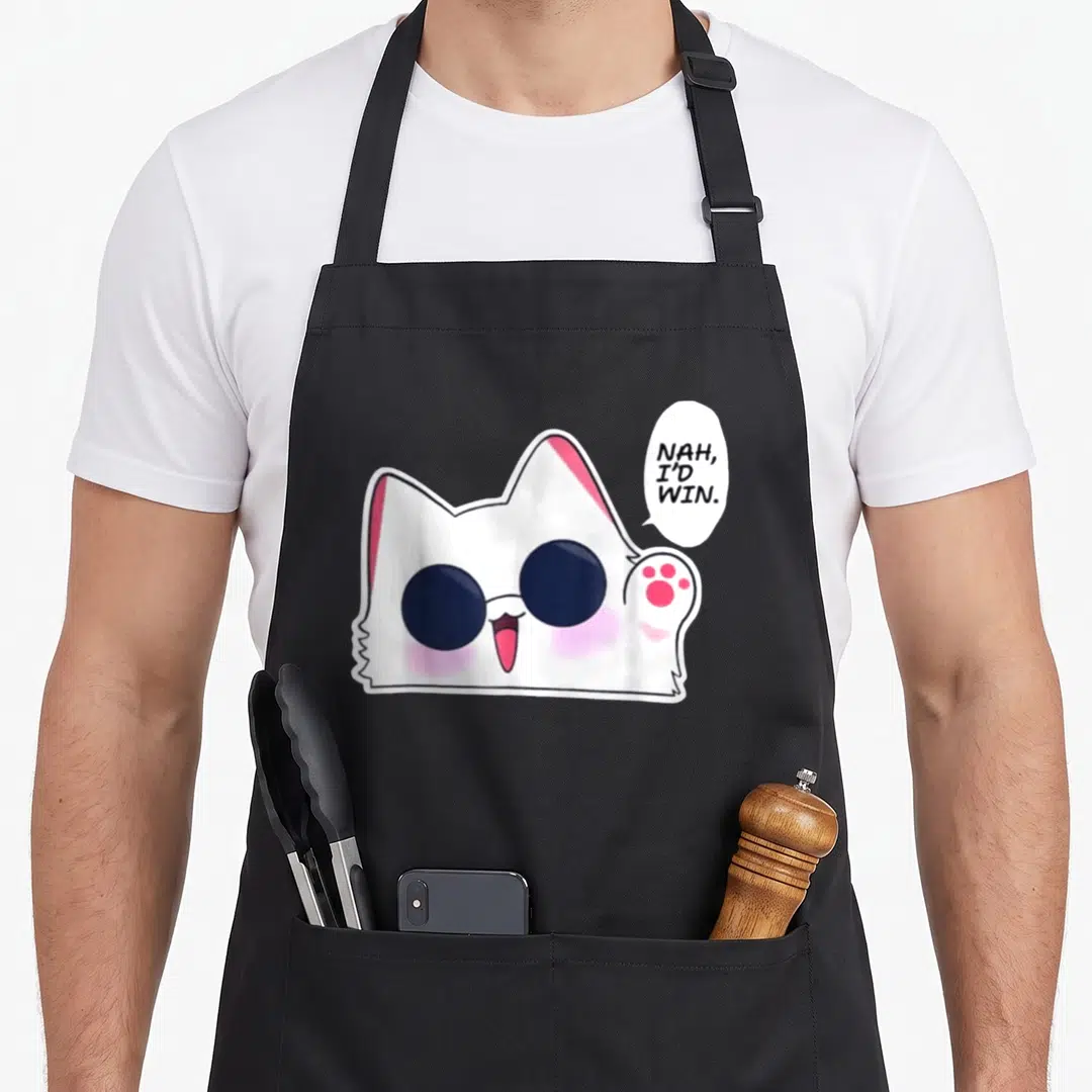 Nah cat apron - White cartoon cat with dark glasses and pink details saying NAH, I'D WIN — shown on a black cotton canvas apron against a white background