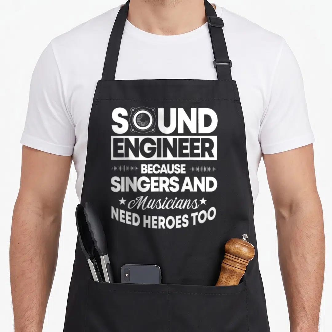 Weil engineer apron - White text SOUND ENGINEER BECAUSE SINGERS AND Musicians NEED HEROES TOO with speaker icon — shown on a black cotton canvas apron against a white background