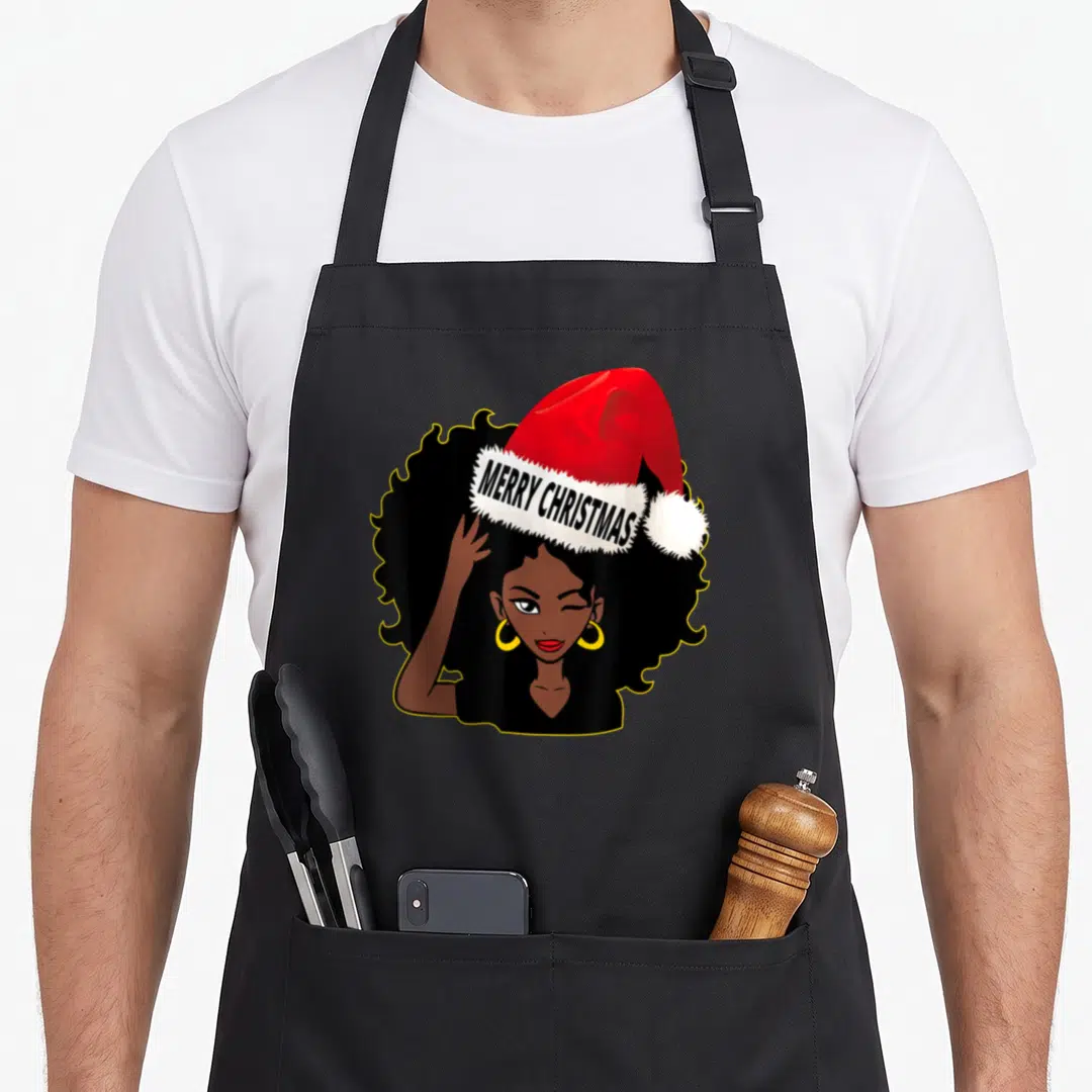 Afro merry christmas apron - Cartoon woman winking wearing red santa hat with MERRY CHRISTMAS text on white trim — shown on a black cotton canvas apron against a white background