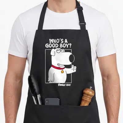 Brian griffin apron - Cartoon white dog with red collar giving thumbs up under stacked white text 'WHO'S A GOOD BOY?' — shown on a black cotton canvas apron against a white background