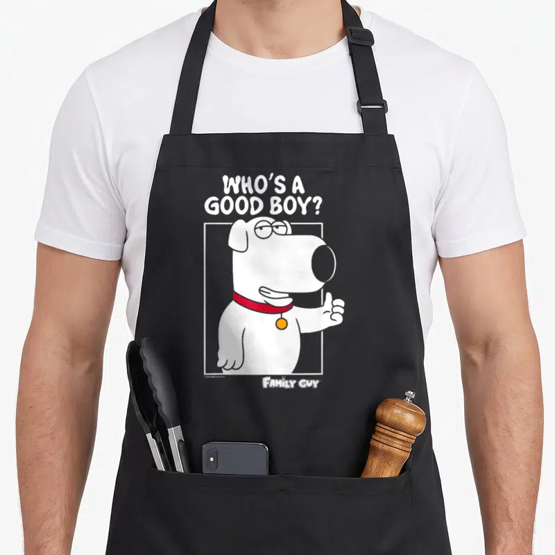 Brian griffin apron - Cartoon white dog with red collar giving thumbs up under stacked white text 'WHO'S A GOOD BOY?' — shown on a black cotton canvas apron against a white background