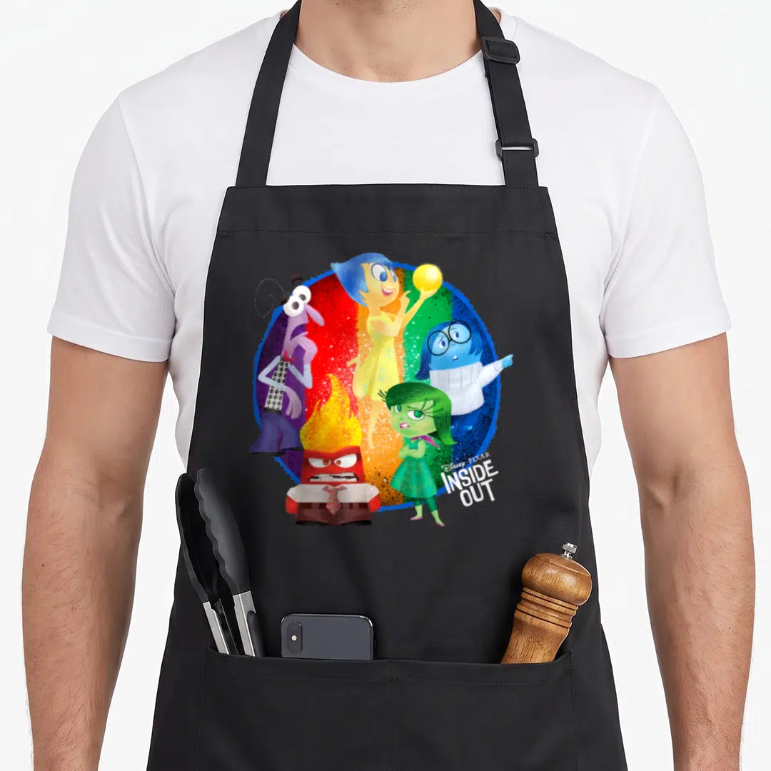 Circle colorful apron - Five cartoon emotions in yellow blue red green purple on rainbow circle with logo — shown on a black cotton canvas apron against a white background