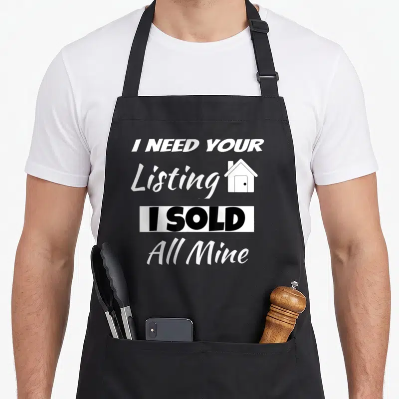 Listing realtor apron - Stacked text I Need Your Listing I Sold All Mine with small house icon beside Listing — shown on a black cotton canvas apron against a white background