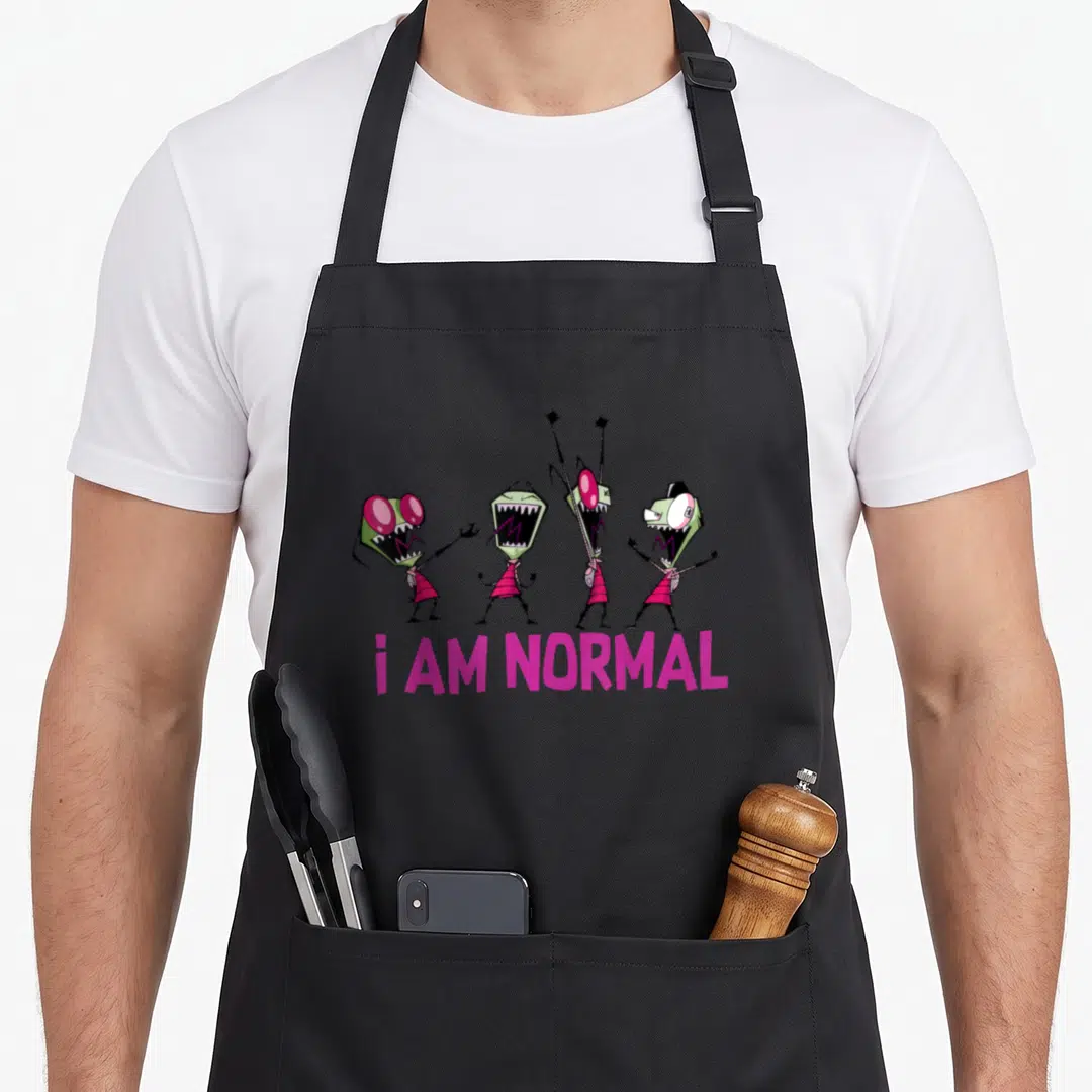 Invader daughter apron - Four green monsters standing in a row above pink i AM NORMAL text — shown on a black cotton canvas apron against a white background