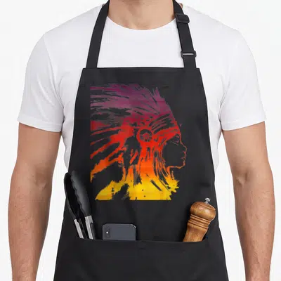Sunset native american apron - Gradient silhouette of a woman in a feathered headdress with purple, red, orange — shown on a black cotton canvas apron against a white background