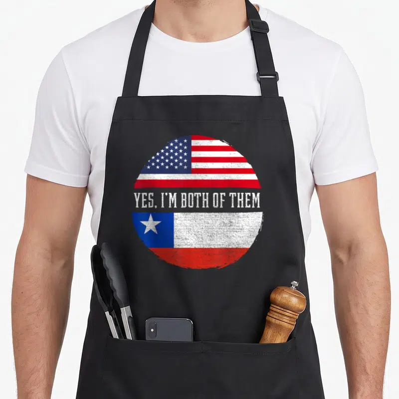 Chilean chile american flag apron - Split circle USA and Chile flags with Yes Im Both Of Them text in distressed style — shown on a black cotton canvas apron against a white background