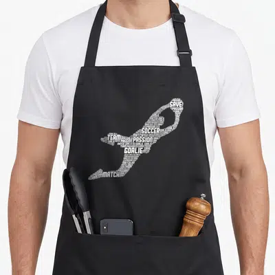 Soccer goalkeeper goalie apron - White typography forming a soccer shoe shape with words SOCCER GOALIE SAVE TEAM — shown on a black cotton canvas apron against a white background
