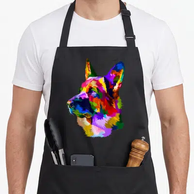Shop dog mom apron - Multicolored pop art German Shepherd head portrait in blue, red, yellow, green, and purple — shown on a black cotton canvas apron against a white background