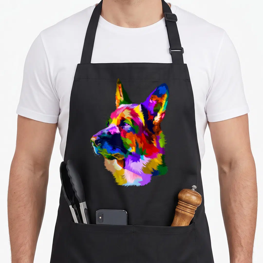 Shop dog mom apron - Multicolored pop art German Shepherd head portrait in blue, red, yellow, green, and purple — shown on a black cotton canvas apron against a white background