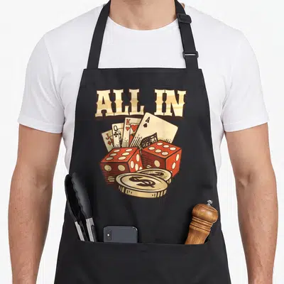 Playing game aprons - ALL IN text above four cards, two red dice, and two gold coins in retro style — shown on a black cotton canvas apron against a white background