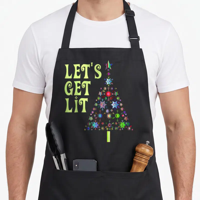 Lit christmas apron - Lime green LET'S GET LIT text next to a geometric tree made of colorful stars and shapes — shown on a black cotton canvas apron against a white background