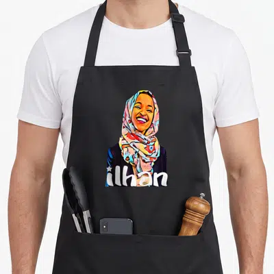 Ilhan political aprons - Cartoon woman in patterned hijab with ilhan text in white, blue, red, yellow — shown on a black cotton canvas apron against a white background