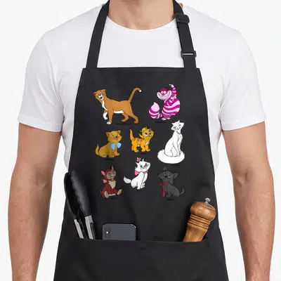 Portrait cat apron - Eight cartoon cats labeled Thomas OMalley, Cheshire Cat, Toulouse, Oliver, Duchess, Dinah, Marie — shown on a black cotton canvas apron against a white background