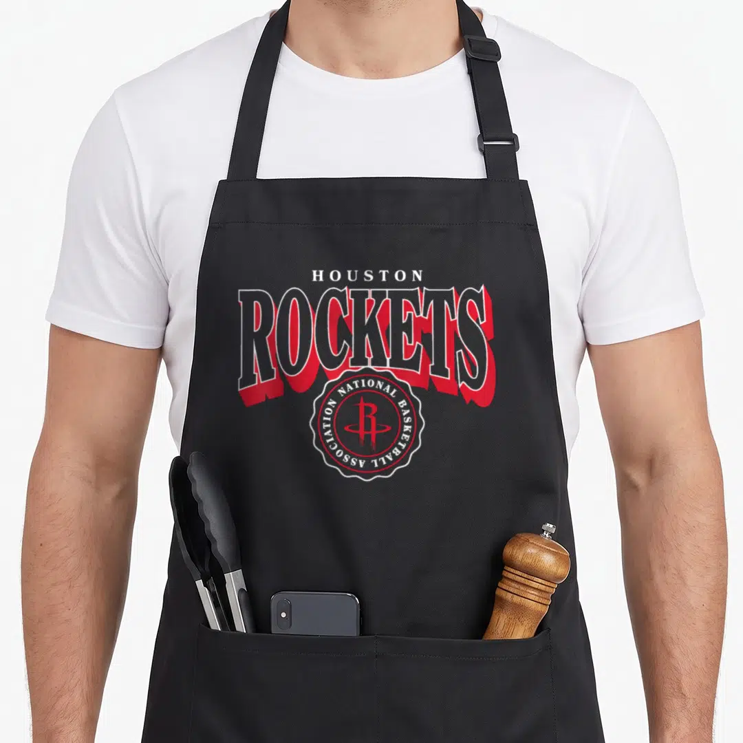 Houston rocket apron - Arched HOUSTON ROCKETS text with red shadow and circular NBA crest logo in red and white — shown on a black cotton canvas apron against a white background