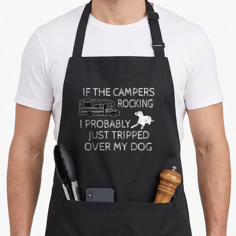 Camper cooking with dog apron - White distressed camper van and dog illustration with pun text on black bib apron — shown on a black cotton canvas apron against a white background