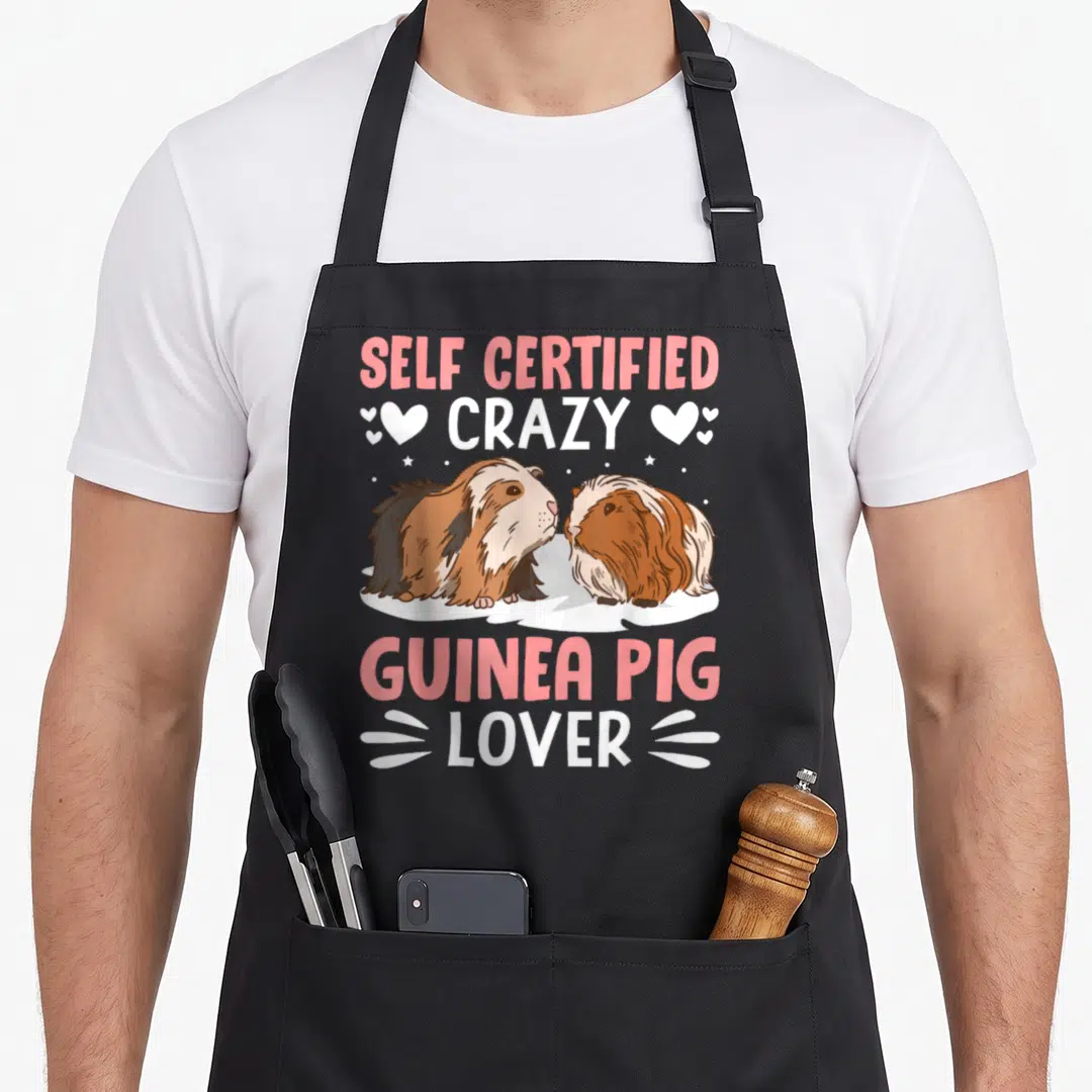 Self pet apron - Two brown and white guinea pigs on a cloud with pink and white text reading Self Certified Crazy — shown on a black cotton canvas apron against a white background