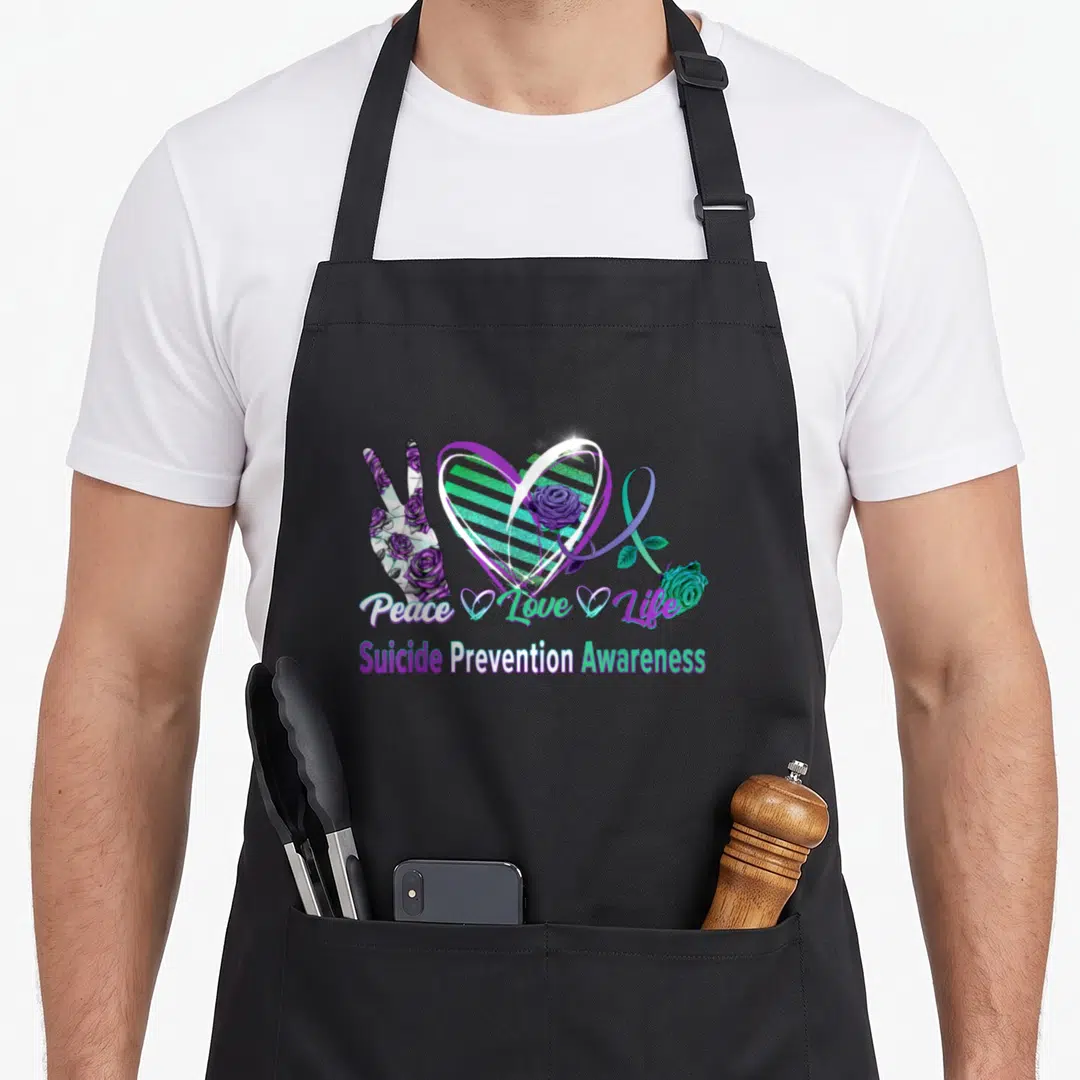Suicide peace love apron - Heart, peace hand, ribbon, and purple teal roses with stacked awareness text — shown on a black cotton canvas apron against a white background