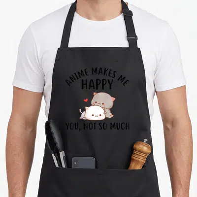 Much anime apron - Two cartoon cats cuddling below text reading ANIME MAKES ME HAPPY YOU NOT SO MUCH — shown on a black cotton canvas apron against a white background