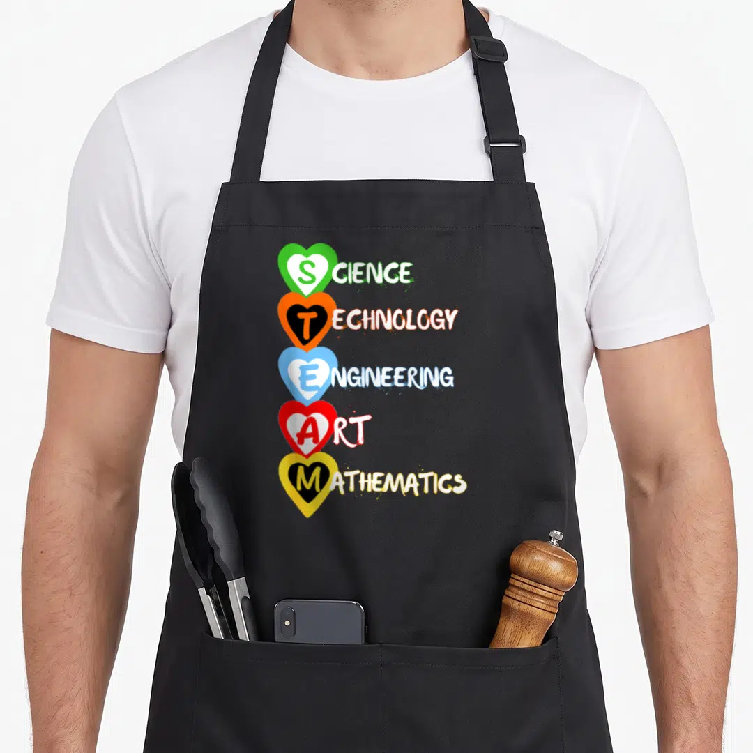 Technical science apron - Five stacked hearts in green orange blue red yellow containing STEAM letters and full words — shown on a black cotton canvas apron against a white background