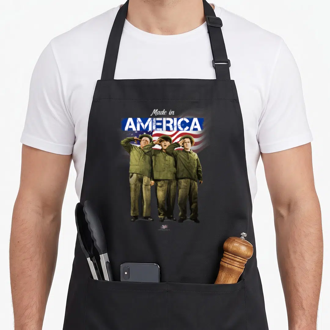 Vtv three stooges apron - Three soldiers in olive uniforms saluting under Made in AMERICA text over flag — shown on a black cotton canvas apron against a white background
