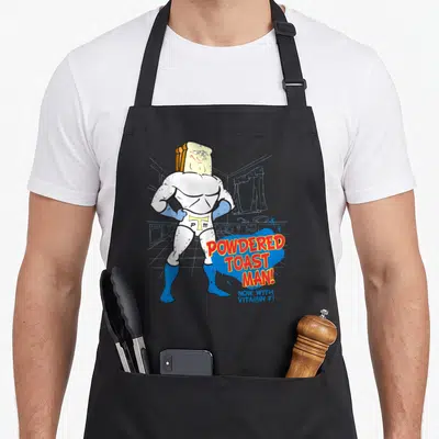 Ren toast apron - Muscular toast head character with red POWDERED TOAST MAN text and blue slogan — shown on a black cotton canvas apron against a white background