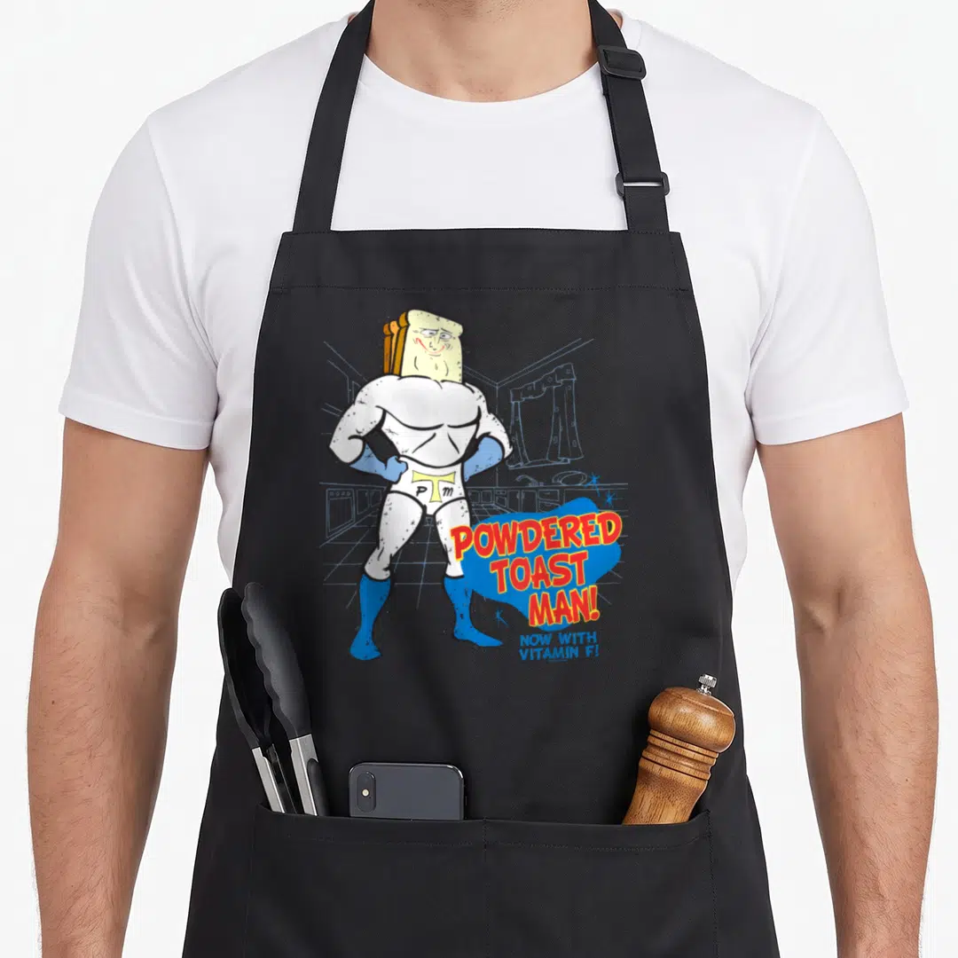 Ren toast apron - Muscular toast head character with red POWDERED TOAST MAN text and blue slogan — shown on a black cotton canvas apron against a white background