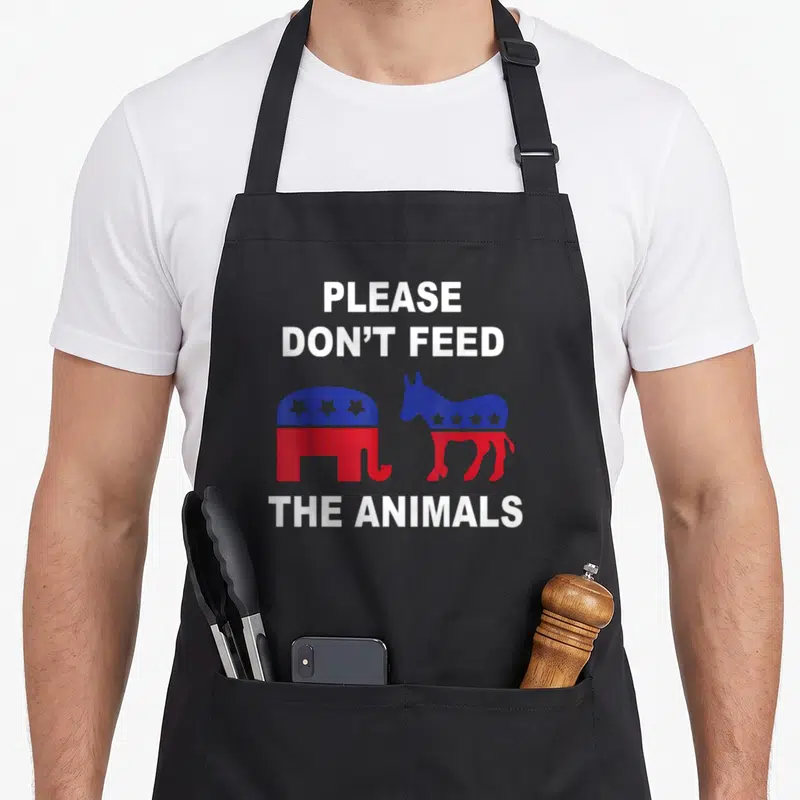 Voting animal apron - Elephant and donkey in red and blue below Please Don't Feed The Animals text — shown on a black cotton canvas apron against a white background