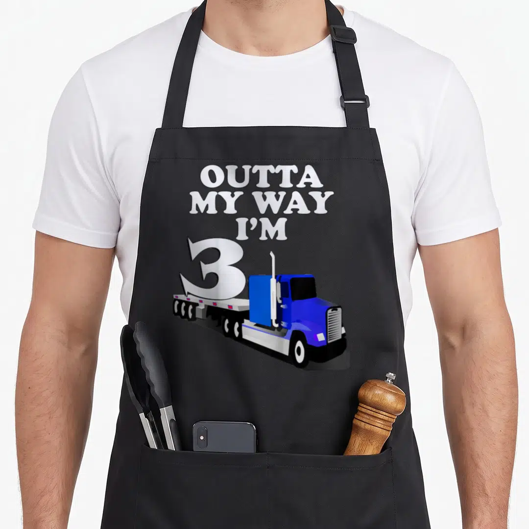 Funny birthday semi truck apron - Blue semi-truck carrying large number 3 with stacked text OUTTA MY WAY I M — shown on a black cotton canvas apron against a white background
