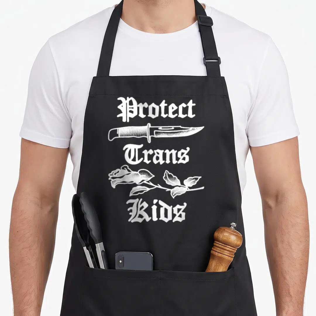 Protect rose apron - White gothic text Protect Trans Kids with knife and rose line art — shown on a black cotton canvas apron against a white background