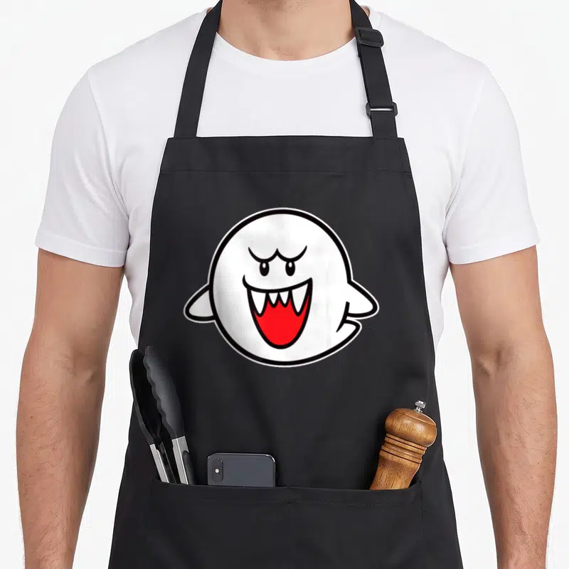 Boo holiday apron - Centered white cartoon ghost with red mouth and black outline on black background — shown on a black cotton canvas apron against a white background