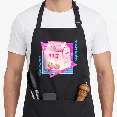 Tokyo milk aprons - Pink milk carton with Strawberry Milk text and vertical Japanese characters on blue grid — shown on a black cotton canvas apron against a white background