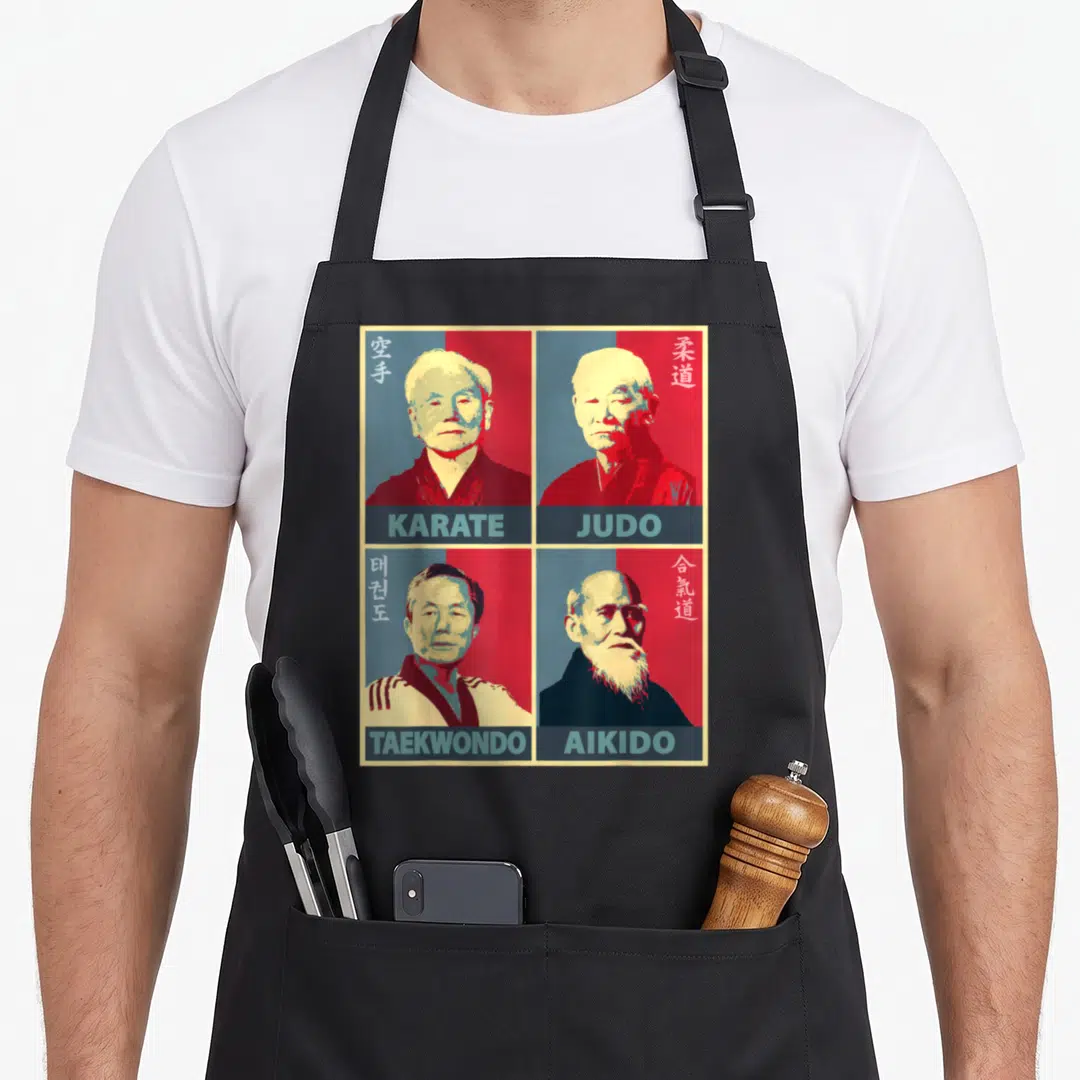 Karate aikido apron - Retro 2x2 grid of four martial arts founders with red blue beige and black backgrounds — shown on a black cotton canvas apron against a white background