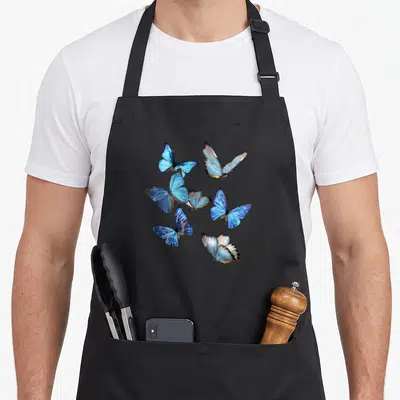 Swarm butterfly apron - Six blue butterflies arranged in a scattered photo-style cluster on a grey background — shown on a black cotton canvas apron against a white background