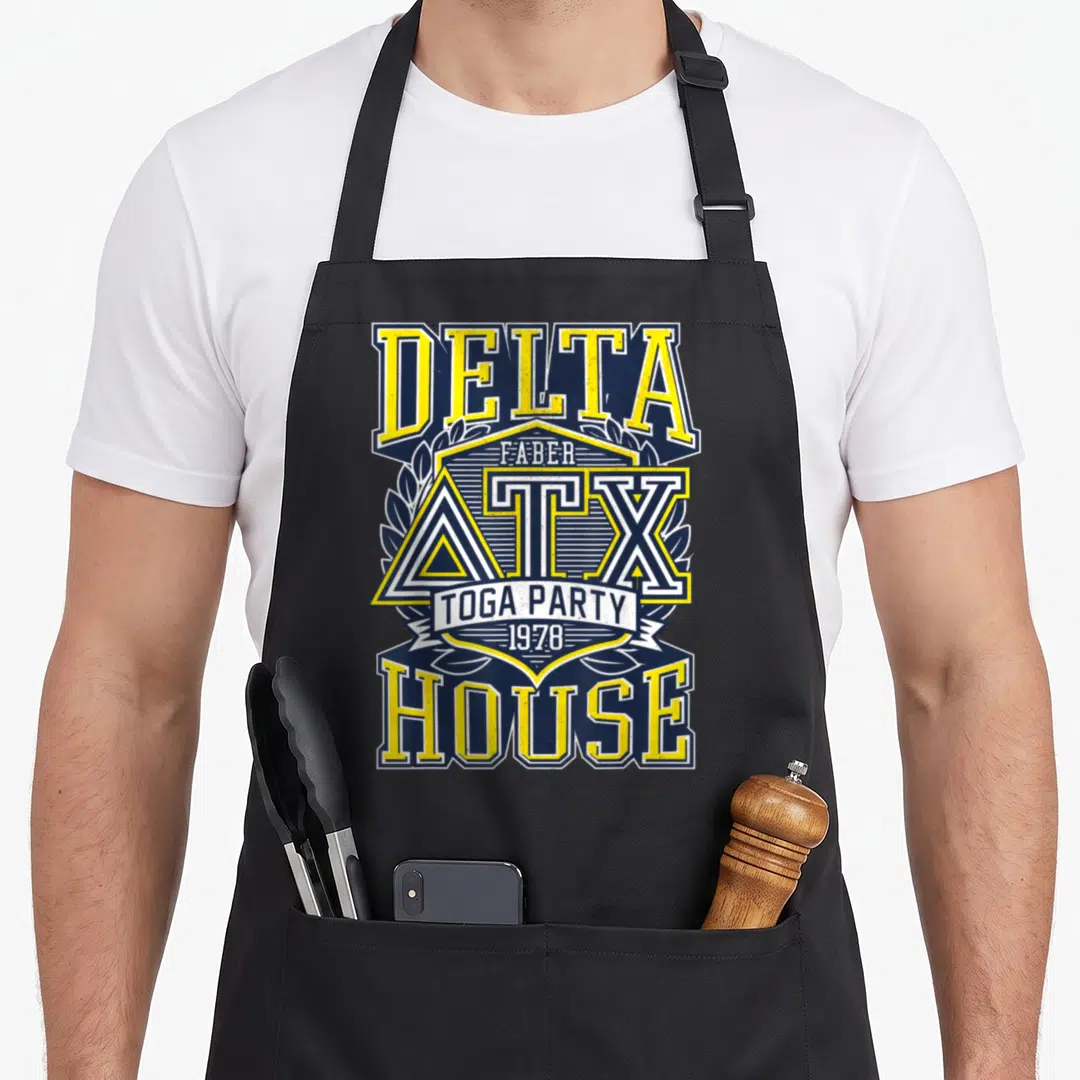 Funny fraternity animal apron - Retro Delta House shield with Faber ATX Toga Party 1978 text in navy and yellow — shown on a black cotton canvas apron against a white background