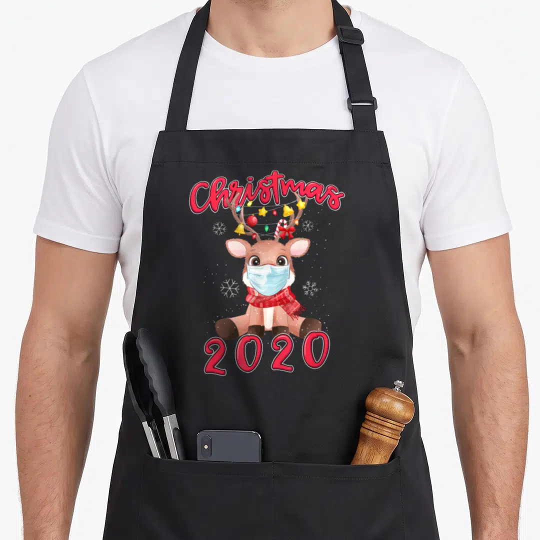 Mask reindeer apron - Cartoon reindeer in blue mask with Christmas 2020 text and red scarf — shown on a black cotton canvas apron against a white background