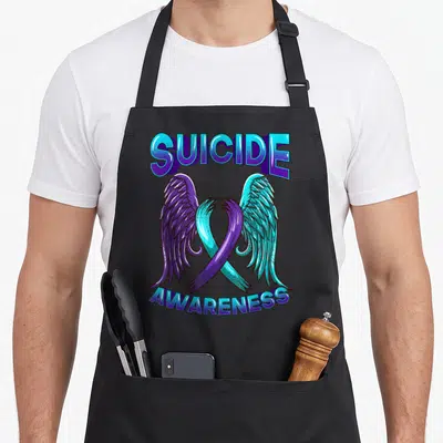 Suicide ribbon apron - Blue and purple awareness ribbon with wings and arched text in cartoon style — shown on a black cotton canvas apron against a white background