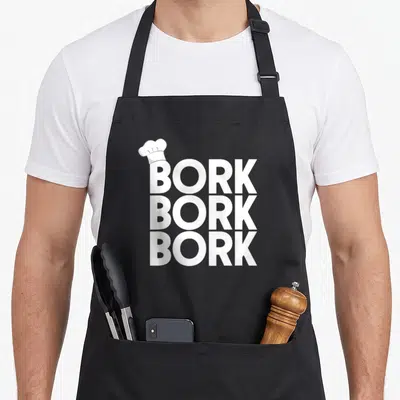 Funny bork swedish apron - Three stacked white BORK text lines with a chef hat on the top left corner — shown on a black cotton canvas apron against a white background