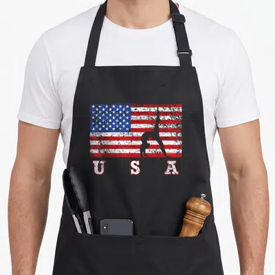 Gymnastic american flag apron - Distressed USA flag with gymnast backbend silhouette and bold lettering below — shown on a black cotton canvas apron against a white background