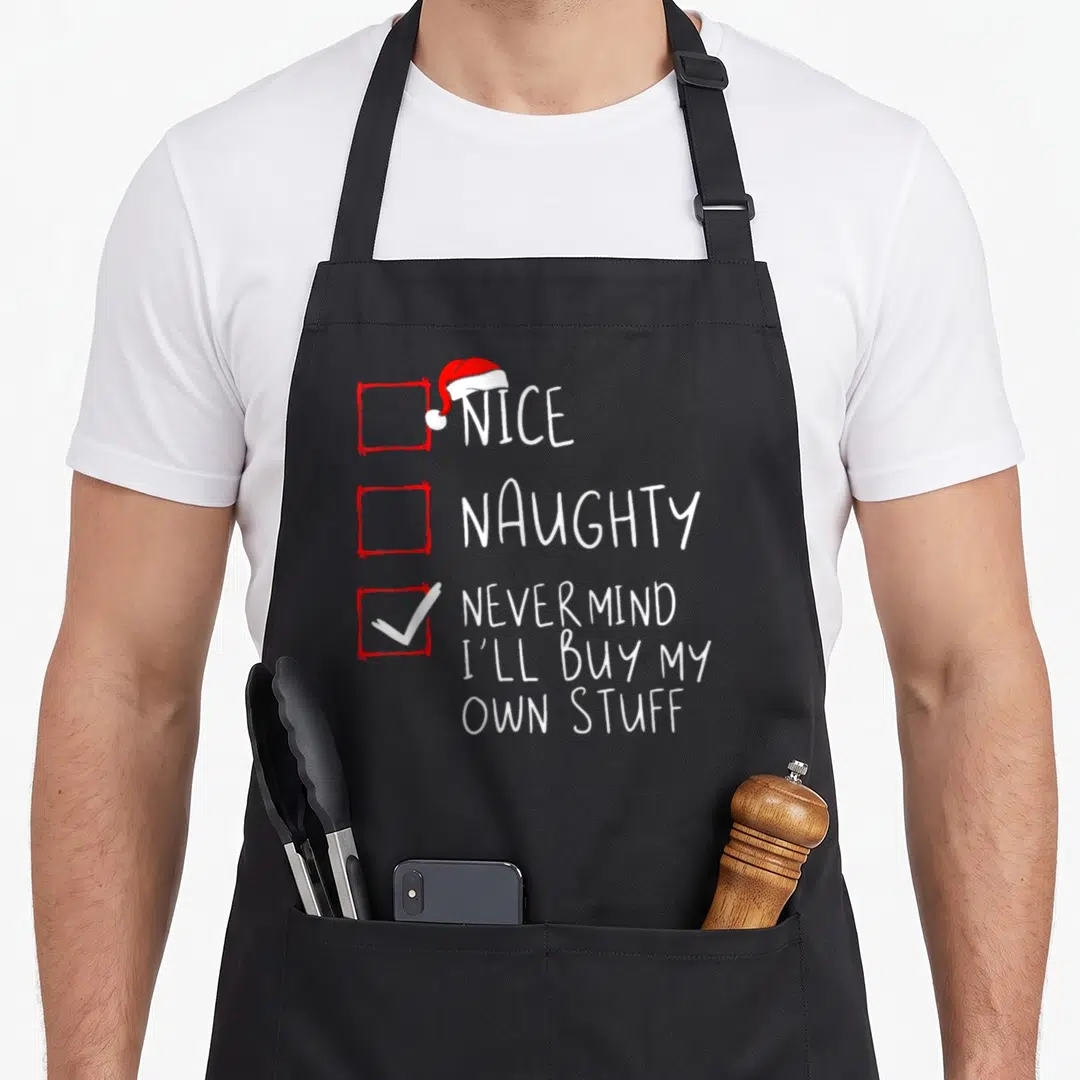 Mind christmas apron - Vertical checklist with three red boxes, Santa hat on first, white checkmark in third, white — shown on a black cotton canvas apron against a white background