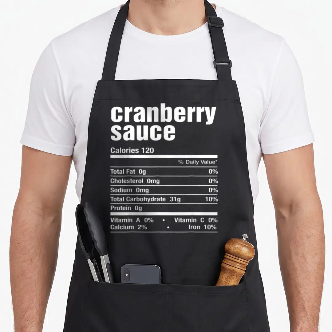 Sauce thanksgiving christmas apron - White nutrition label typography reading cranberry sauce zero fat calories 120 — shown on a black cotton canvas apron against a white background
