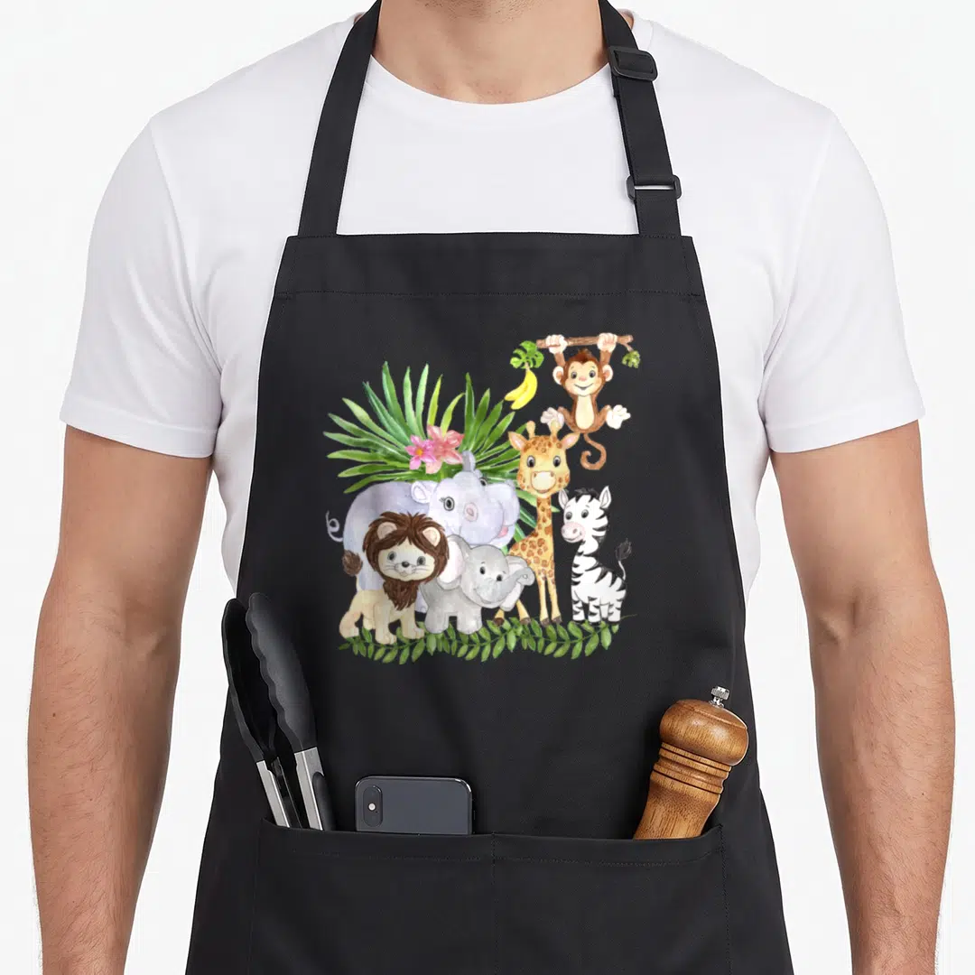 Animal wildlife birthday apron - Watercolor jungle animals including lion, elephant, giraffe, zebra, and monkey — shown on a black cotton canvas apron against a white background