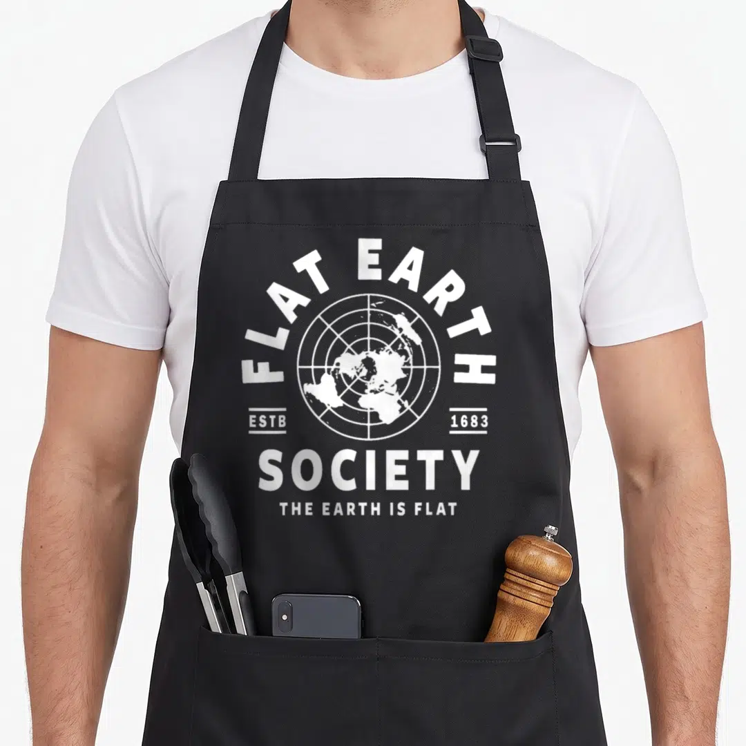Flat earth society earther apron - White circular flat earth map with grid and ESTB 1683 text — shown on a black cotton canvas apron against a white background