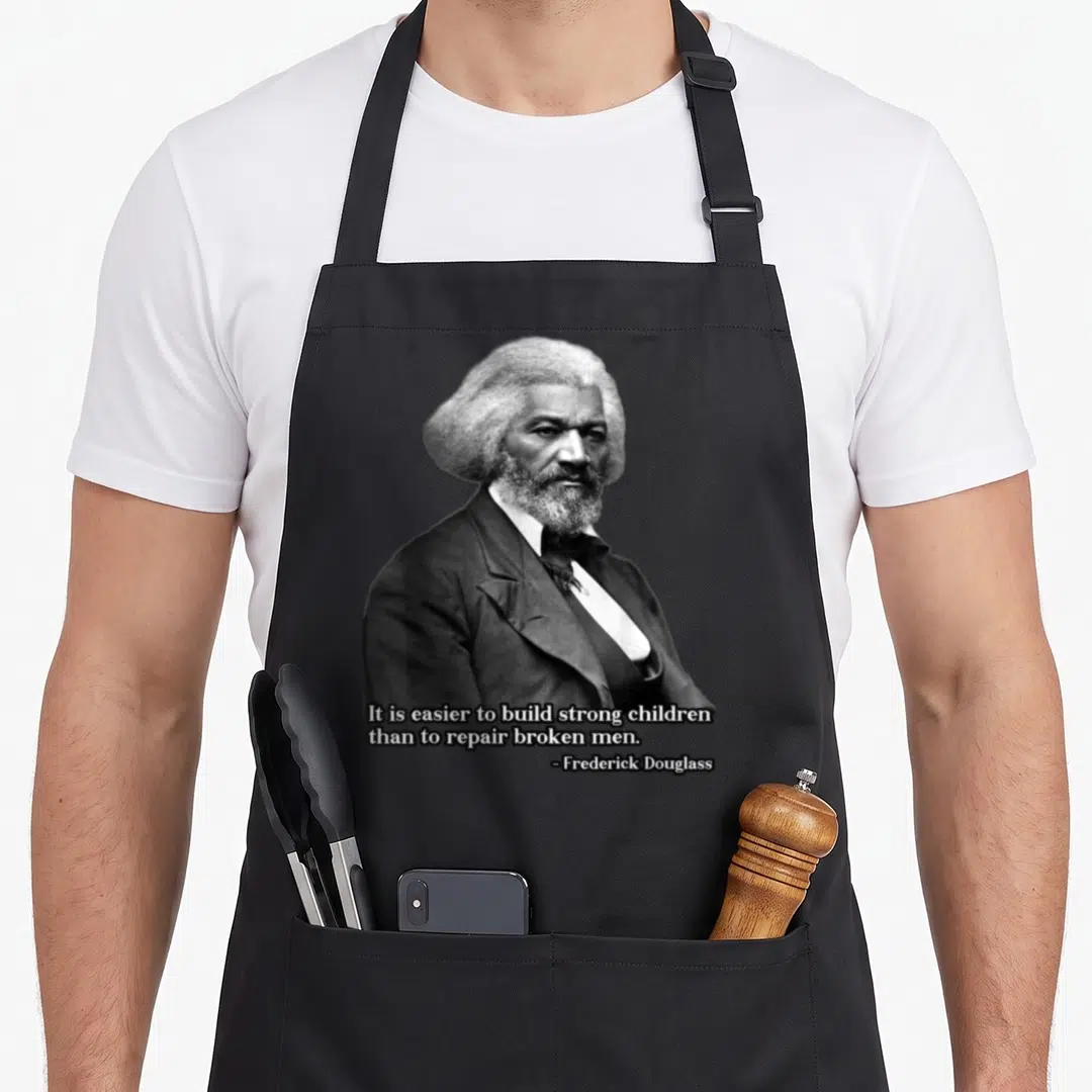 Frederick thats right and apron - Grayscale portrait of Frederick Douglass above quote about building strong children — shown on a black cotton canvas apron against a white background