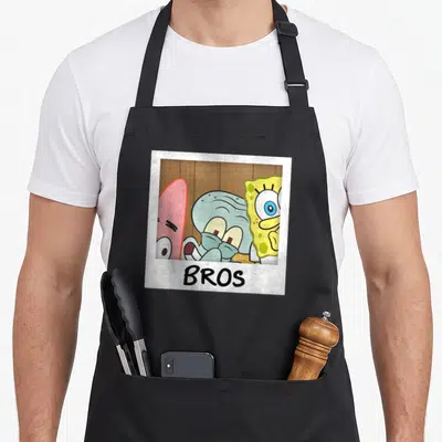 Squarepant us aprons - Three cartoon characters in a white polaroid frame with BROS text on the bottom border — shown on a black cotton canvas apron against a white background